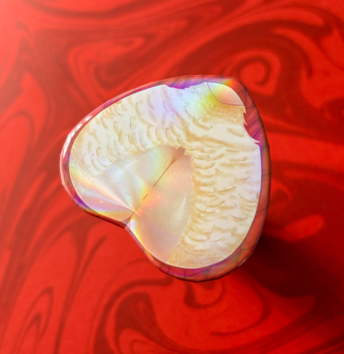A heart-shaped product with a holo sheen, predominantly white and pink in color. Displays Falin from anime Dungeon Meshi (Delicious In Dungeon)