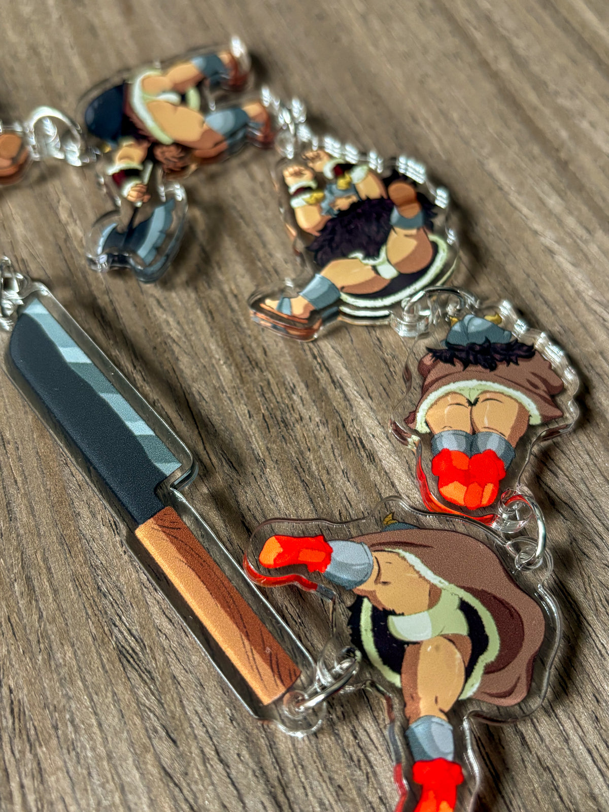 This image displays the Crotch Shot Senshi Acrylic Charm Chain, featuring a bold and playful design with an array of colorful, character-themed charms. The large, ornate chain, approximately 20 inches in length, includes intricate clasps and is designed to be versatile, used either as a bag or pants chain.